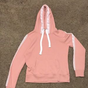 Pink hoodie with white white stripes on side and the words “love”.